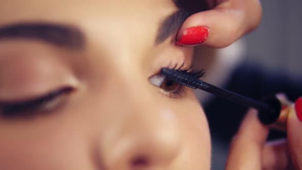 Closeup View of Professional Makeup Artist Applying Mascara on the Model's Eyelashes