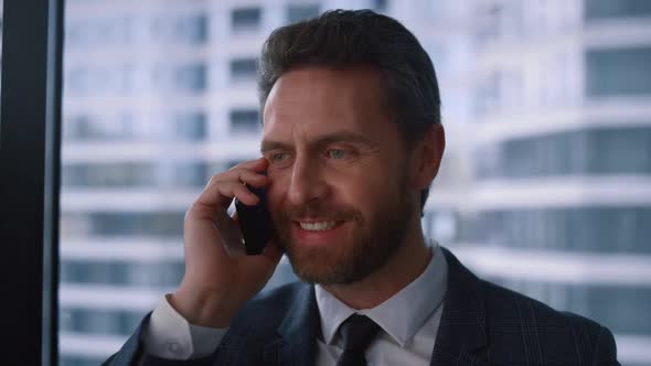 Friendly Businessman Talking Phone Making Corporate Call in Modern Window Office