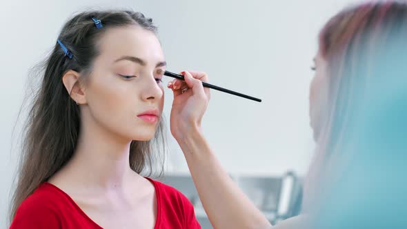 Closeup Model Face During Working of Professional Female Makeup Artist Applying Eyeshadow