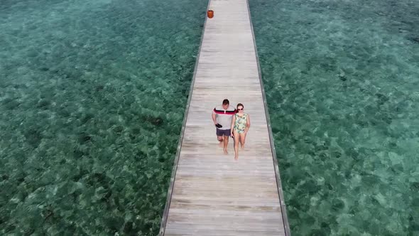 A Man and a Woman Couple Walking on Wooden Decking Bridge Holding Hands