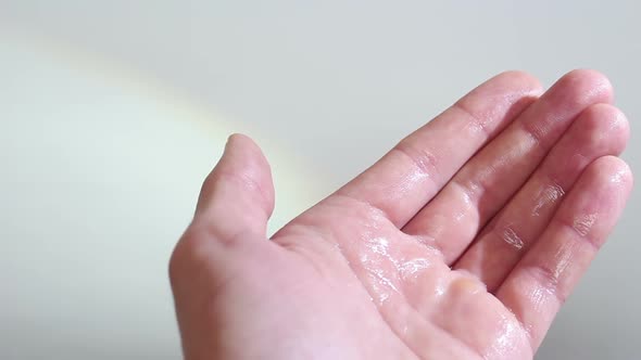 A Young Guy Disinfects His Hands with an Antiseptic