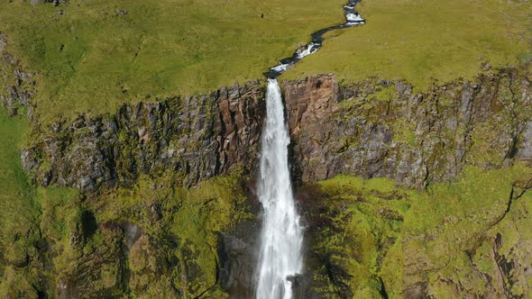 Aerial Drone Footage of Bjarnarfoss Waterfall Green Cliffs and Plateau in Western Iceland