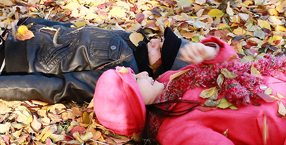 Two Girls Lying On Top Of Leaves