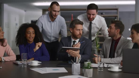 Multiethnic Team Using Tablet Device Analyzing Finance on Office Conference