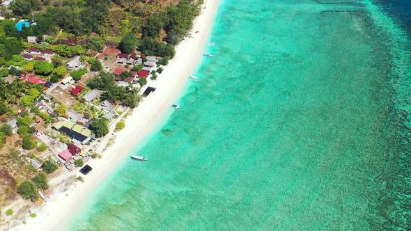 Large turquoise lagoon with calm clear water over white pebbles around tranquil exotic beach in fron