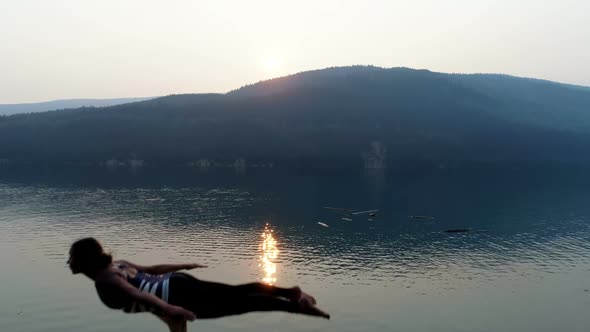 Women practicing acroyoga near lakeside 4k