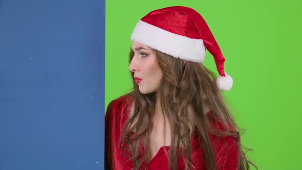 Santas Assistant Looks Out of the Blue Board and Shows a Thumbs Down. Green Screen