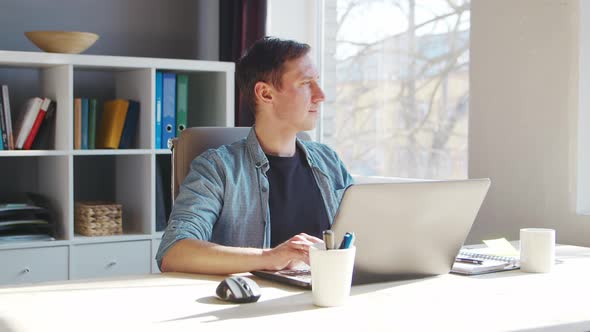 Young male entrepreneur works at home office at the computer.