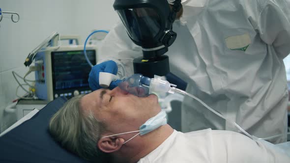 Patient with an Oxygen Mask on Him is Getting His Temperature Checked