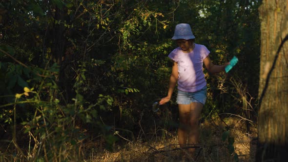 Tracking Shot of the Child Girl in Search of Adventure in the Forest Discovers the Surrounding World