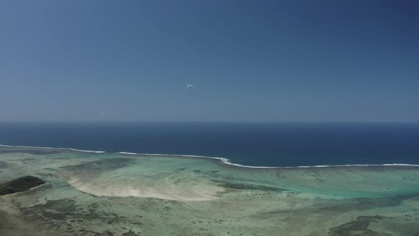 Aerial view of a person doing paragliding among the mountain, Mauritius.