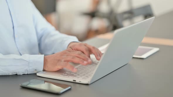 African Hands Typing on Laptop