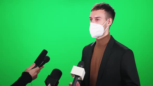 Caucasian Man in a Medical Mask Gives an Interview to Journalists Communication During the