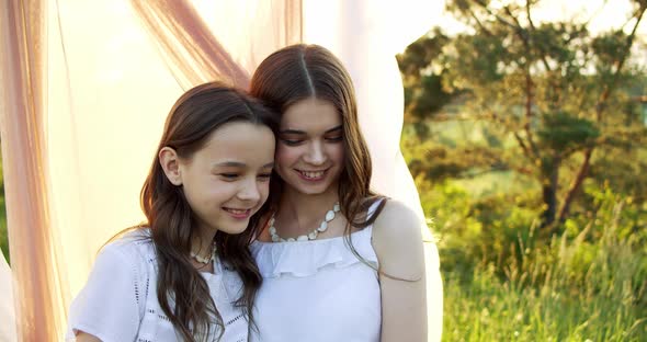 Playful Girls Hugging on Summer Nature at Countryside