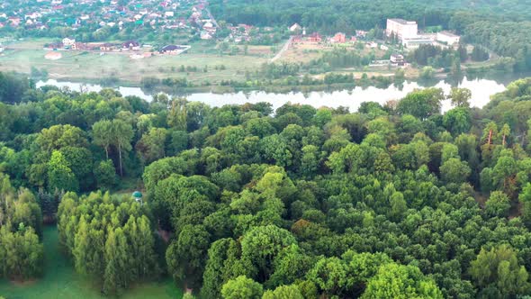 Nice top view of the park, forest covered with greenery. Morning river in fog.