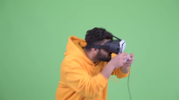 Young Overweight Bearded Indian Man Playing Games and Using Virtual Reality Headset