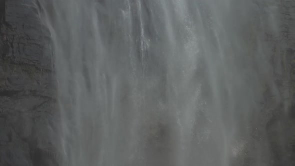 Large Waterfall Surrounded By Cliffs Falls with Water Mist