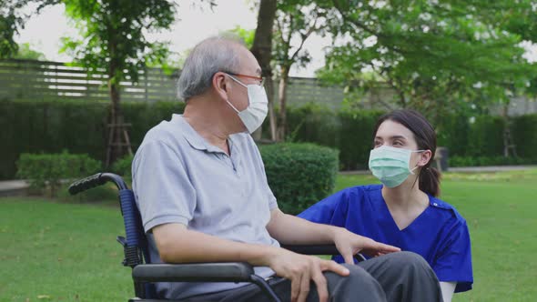 Caregiver young woman doctor wear face mask, support disabled senior elder man on wheelchair.