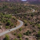 Car Drives on Winding Road Among Scrublands in Highland - VideoHive Item for Sale
