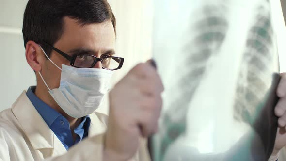 Doctor Looks at an X-ray of the Lungs. Coronavirus Concept.