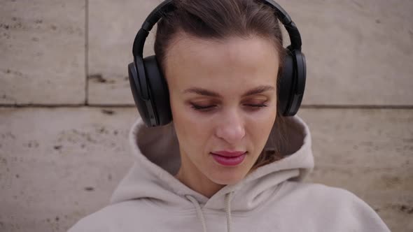 Young Woman Listening to Music in Headphones Outdoor