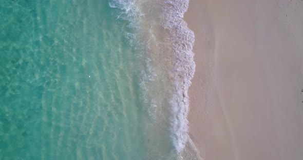 Tropical flying abstract view of a white sand paradise beach and blue ocean background in hi res 4K