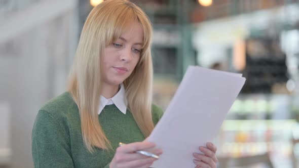 Portrait of Young Woman Reading Documents Paperwork