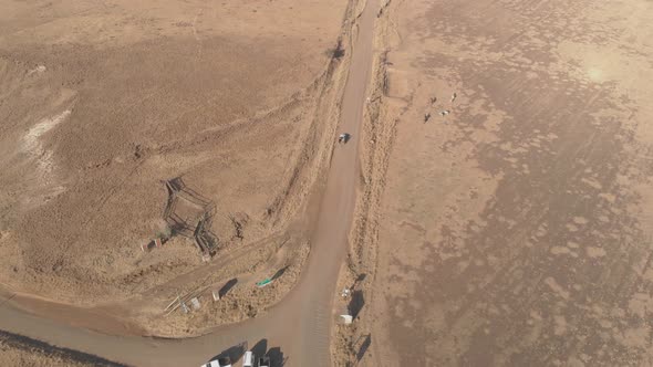 aerial shot following a pickup truck on a gravel road