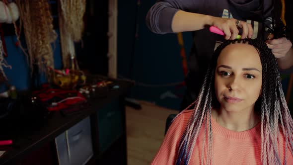 A Female Stylist Attaches Senegalese Braids to a Woman in a Beauty Salon