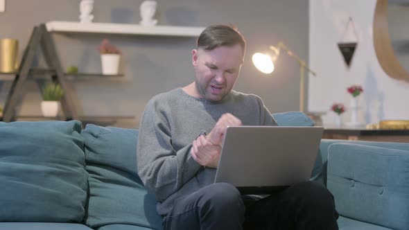 Casual Manwith Laptop Having Wrist Pain on Sofa