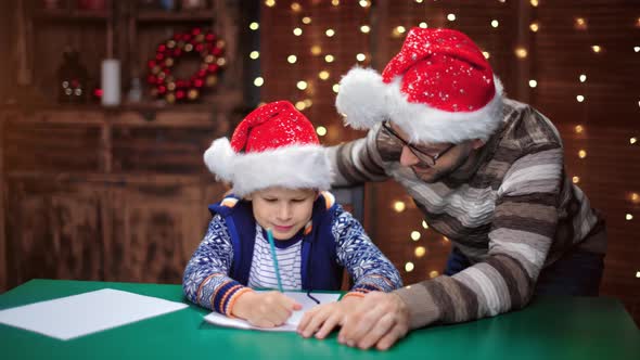 Happy Father and Son Writing Wish List to Santa Claus at Christmas Decor