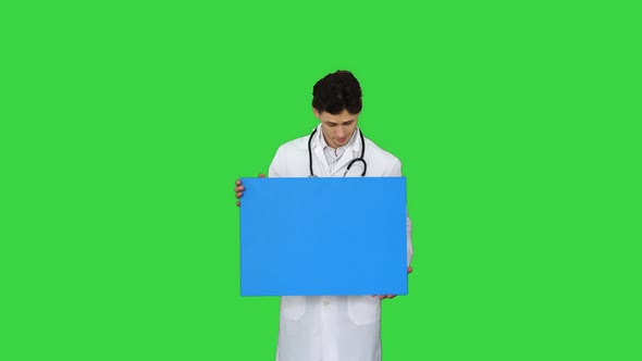 Smiling Male Doctor Wearing a Stethoscope Holding Blank Poster on a Green Screen, Chroma Key.