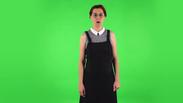 Funny Girl in Round Glasses Is Scolding and Shaking Her Index Finger. Green Screen