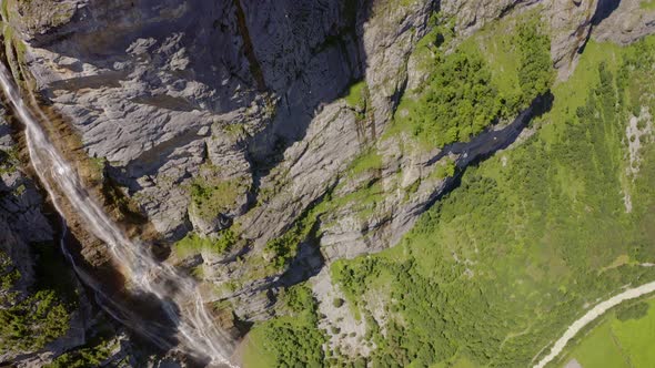 A drone shot of the lauterbrunnen valley. The camera moves from the bottom of the waterfall to the t