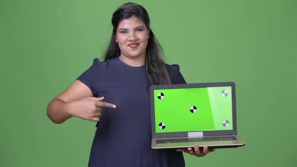 Young Overweight Beautiful Indian Businesswoman Against Green Background