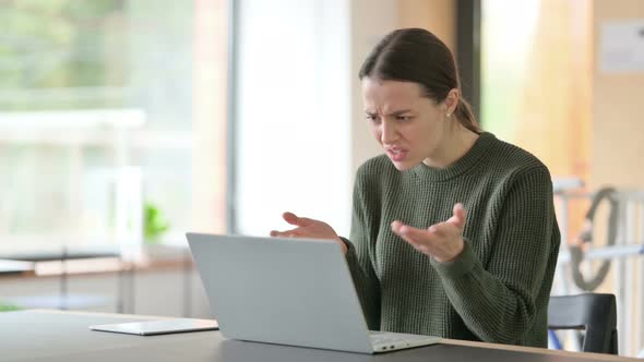 Young Woman Reacting To Loss on Laptop 