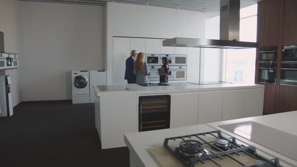 Senior Couple Buying New Contemporary Kitchen in Showroom