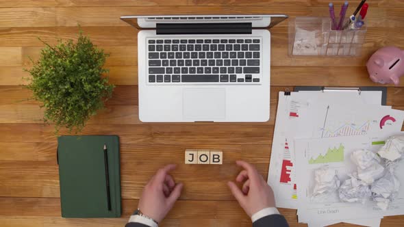 Job Word of Wooden Cubes is Removed with Hands From the Office Table