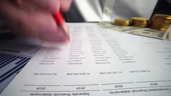 Accountant analyzing business marketing data on paper dashboard at office table.