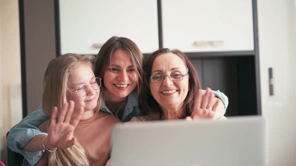 Grandmother Mother and a Grandchild Waving Hands While Taking a Video Call