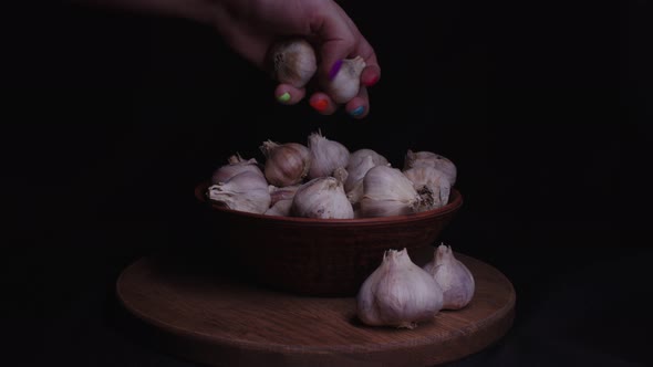 Pile of Whole Bulbs of Garlic in Ceramic Bowl on Table