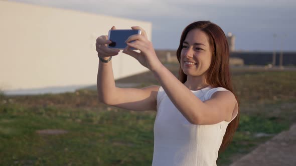 Beautiful Smiling Redhead Woman Taking Selfie with Smartphone