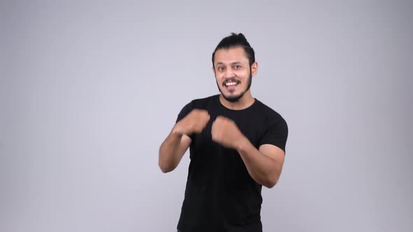 A happy Indian young adult cheering to the camera