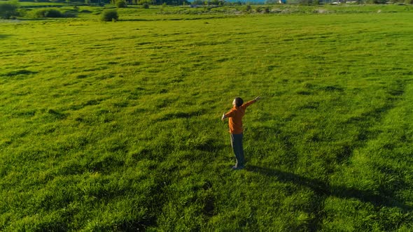 Low Altitude Radial Flight Over Sport Yoga Man at Perfect Green Grass