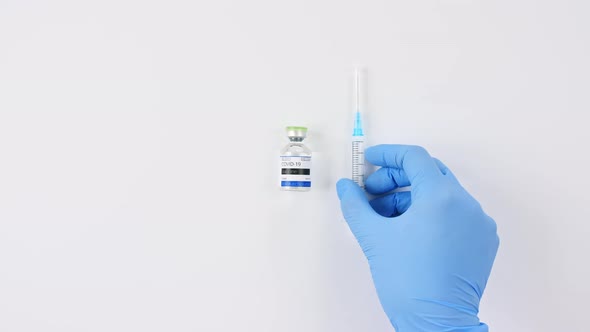COVID19 Vaccine in Researcher Hands Doctor Puts on the Table Syringe and Bottle with Vaccine for