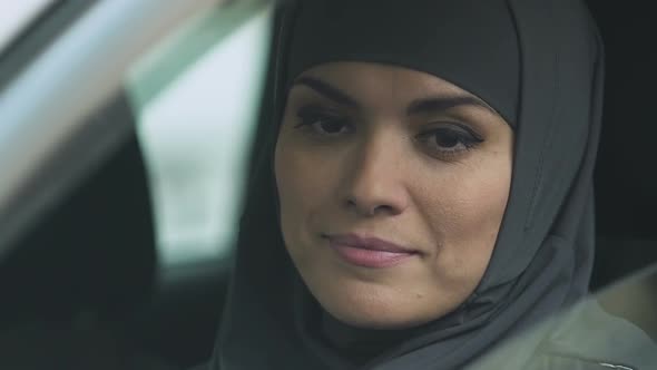 Muslim Woman Rolling Car Window Down to Check Road, Attentive Driver, Closeup