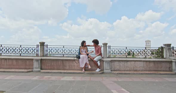 Romantic Couple Sitting on Bench Talking Feeling Free and Happy To the Main Square in Rural Town 