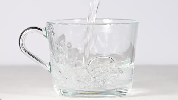 Pouring hot water in tea or coffee glass cup