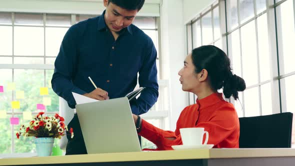 Two Business People Talk Project Strategy at Office