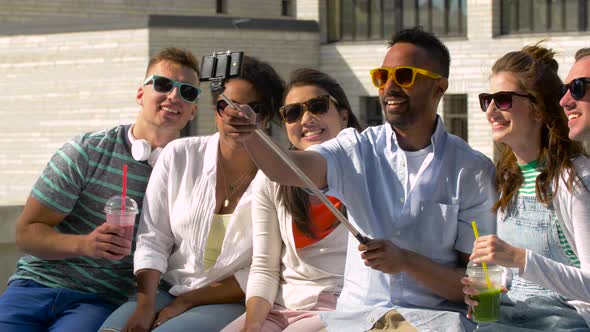 Friends Taking Picture By Selfie Stick in City 